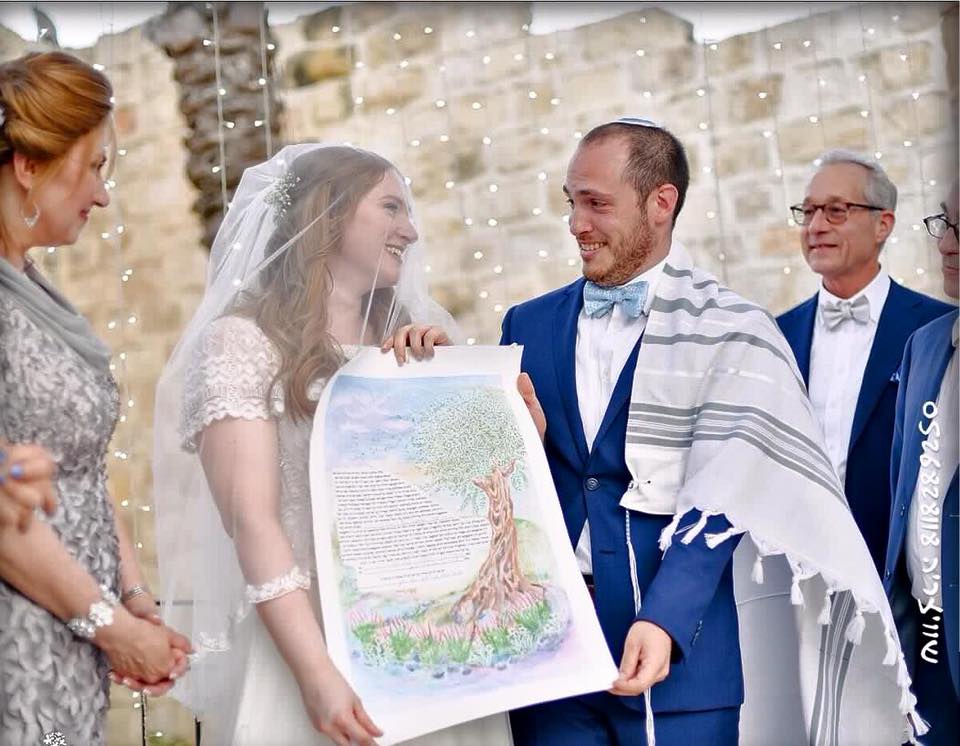 Jordana holding custom hand painted ketubah by Avigail Sapir