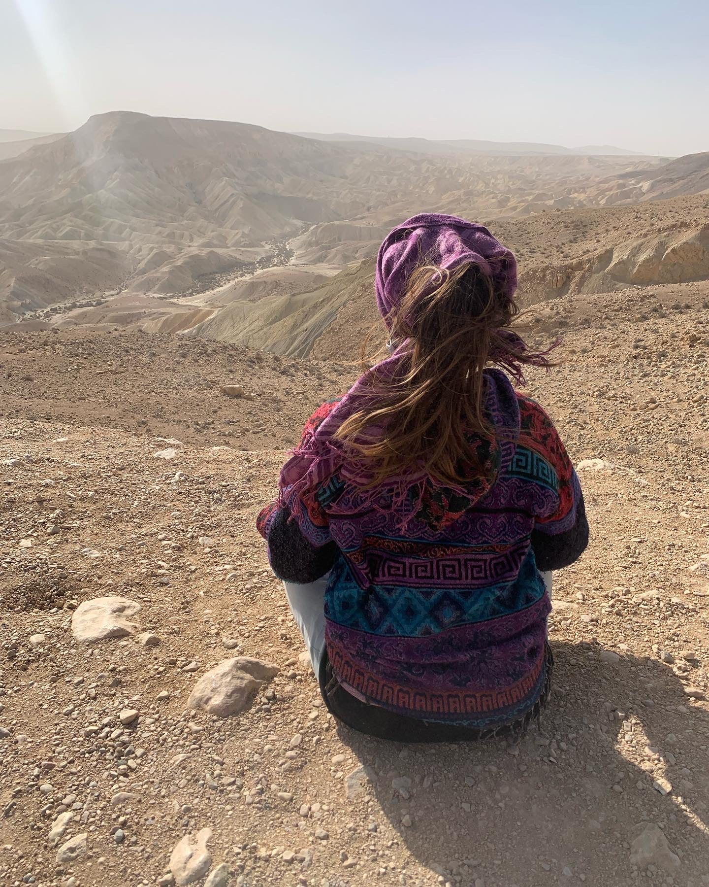 Avigail Sapir, Ketubah Artist, sitting and looking out into the mountains
